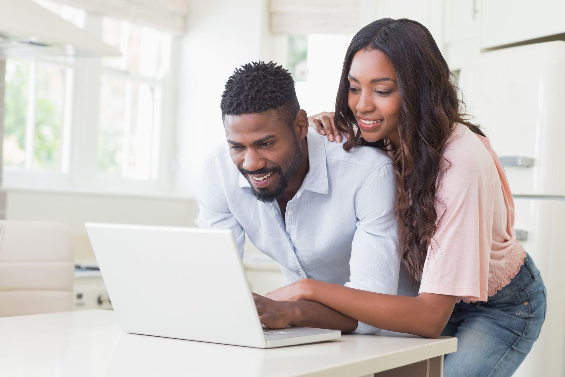 A husband and wife view their second chance checking account balance online.